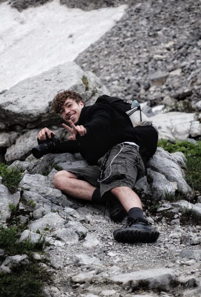 Yannis Hirsch mit Kamera in den Bergen